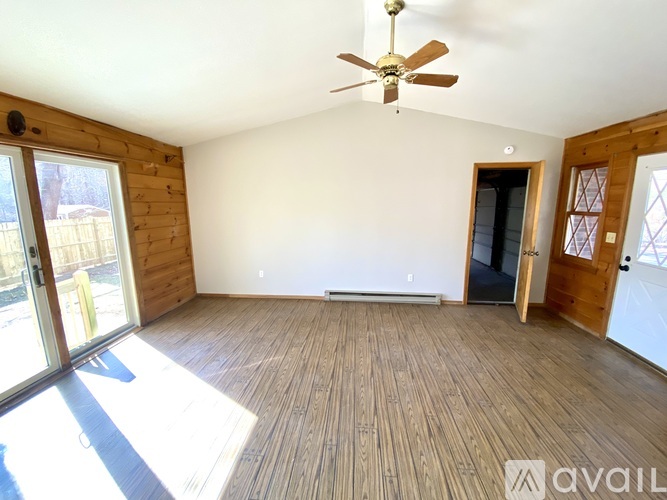 A room with wooden floors and a ceiling fan.