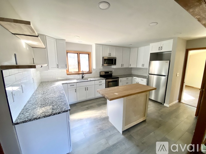 A kitchen with white cabinets and a granite countertop.