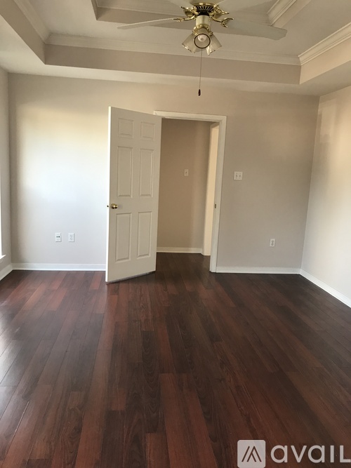 A room with a wooden floor and a ceiling fan.