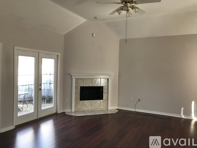 A living room with a fireplace and a ceiling fan.