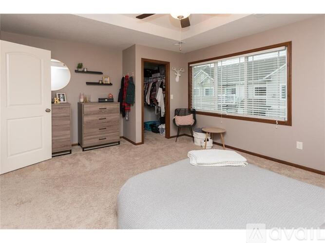 A bedroom with a bed, dresser, and window.