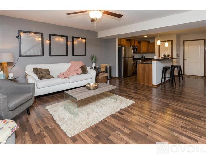 A living room with a white couch and a wooden floor.