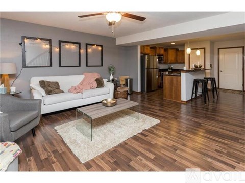 A living room with a white couch and a wooden floor.