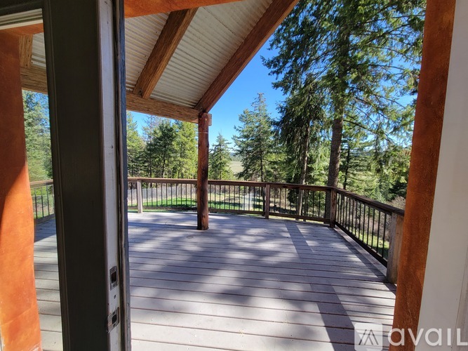 A deck with a railing and trees in the background.