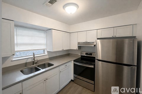 A kitchen with white cabinets and stainless steel appliances.