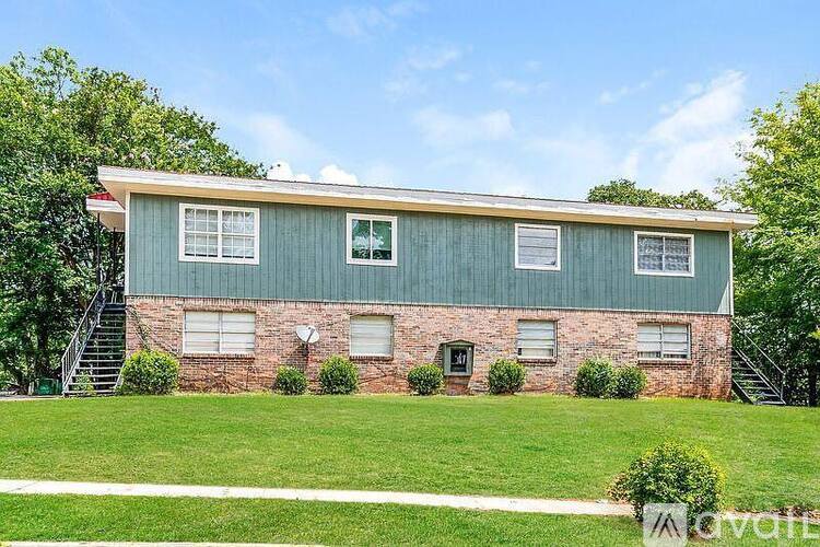 A two-story house with a green roof and brick walls.