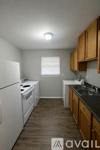 A kitchen with wooden cabinets and a white fridge.