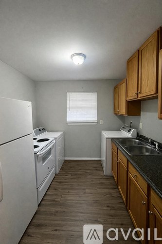 A kitchen with wooden cabinets and a white fridge.