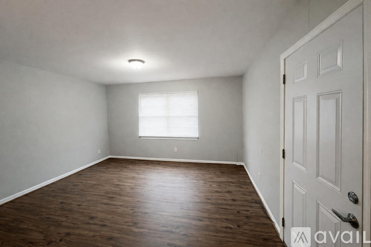 A room with wooden flooring and a white door.