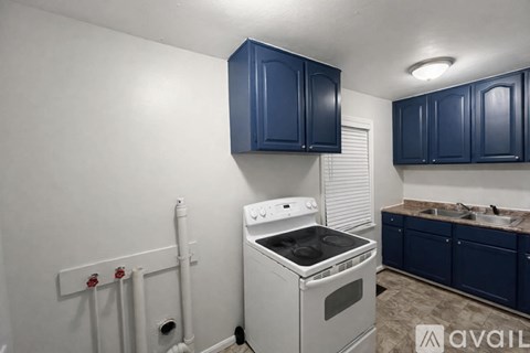 A kitchen with a white stove and blue cabinets.