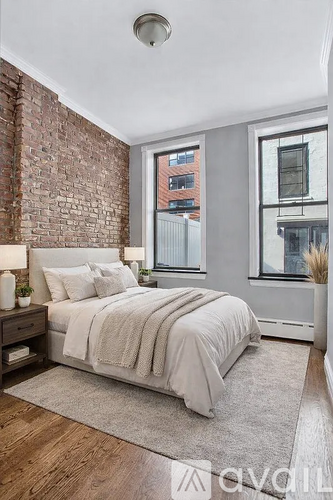 A bedroom with a brick wall and a large bed.