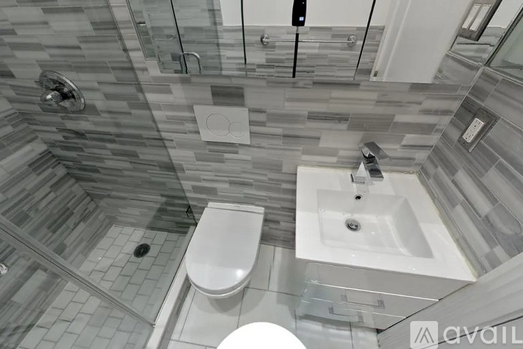A modern bathroom with a glass shower stall and a white toilet.