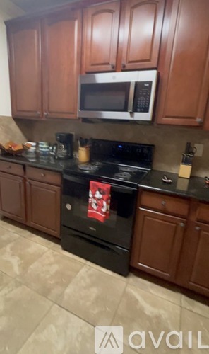 A kitchen with brown cabinets and a black stove top.