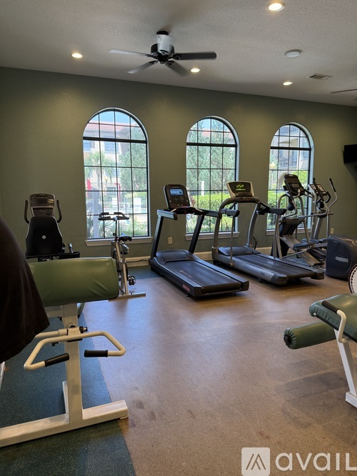 A gym with treadmills, exercise bikes, and weights.