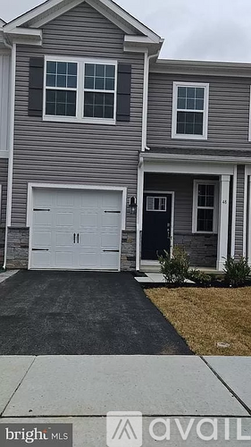 A grey house with a white garage door and a black door.