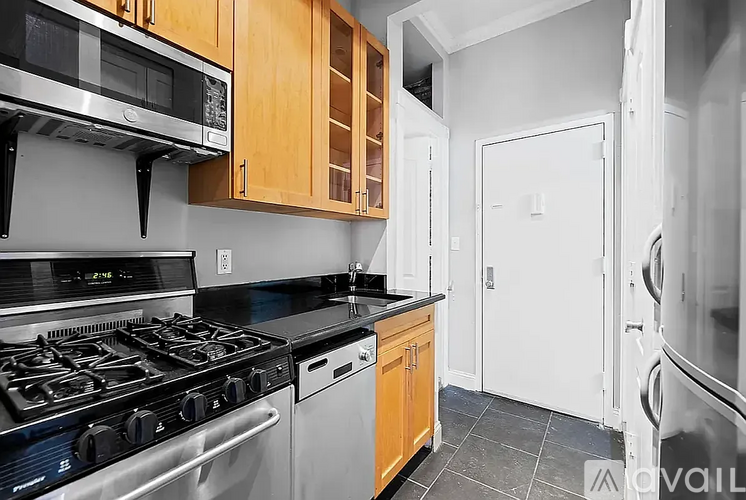 A kitchen with a black stove top oven and a microwave above it.