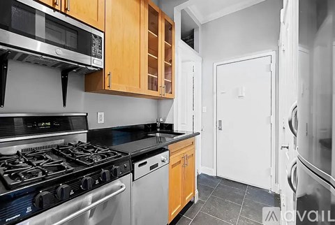 A kitchen with a black stove top oven and a microwave above it.