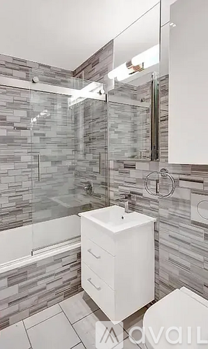 A white sink in a modern bathroom with a glass wall.