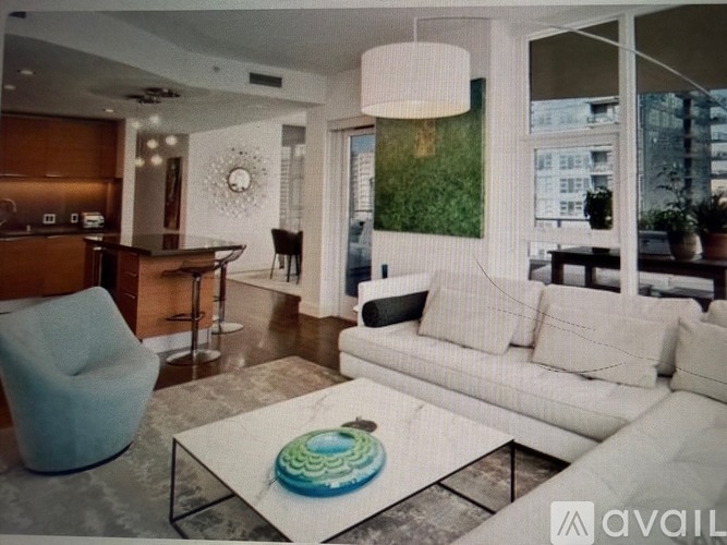 A living room with a white couch and a glass coffee table.