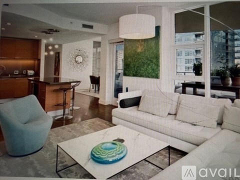 A living room with a white couch and a glass coffee table.