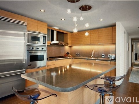 A modern kitchen with stainless steel appliances and wooden cabinets.