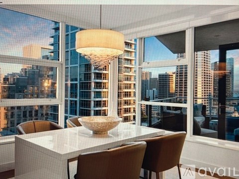 A modern dining room with a view of the city skyline.