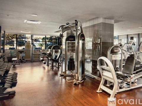 A gym with a variety of equipment including treadmills, weights, and exercise machines.