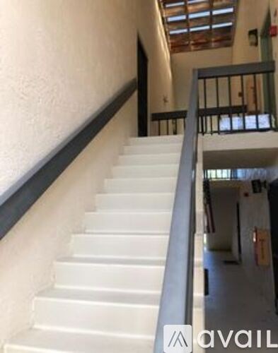 A staircase with a metal railing and white steps.