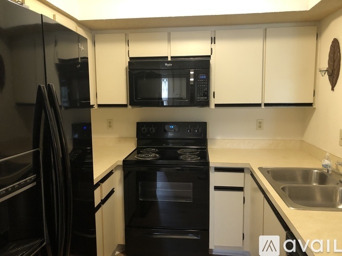 A kitchen with black appliances and white cabinets.