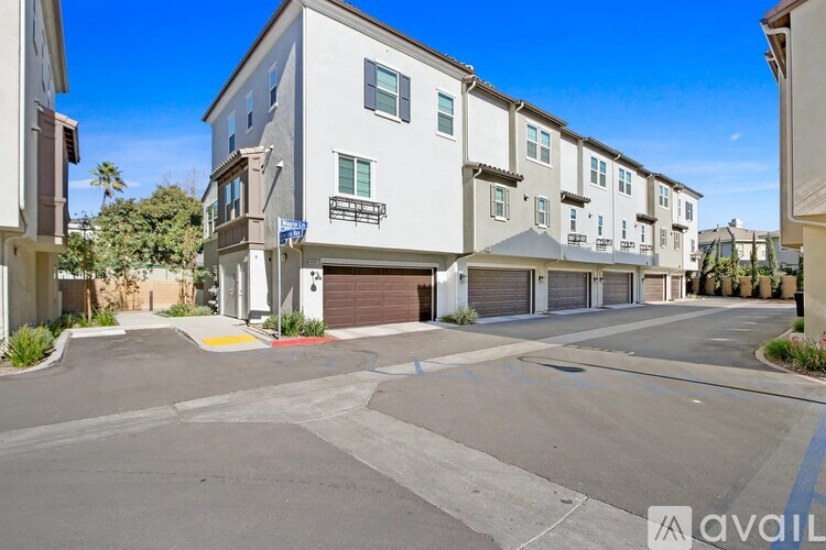 A row of modern townhouses with a clear blue sky above.