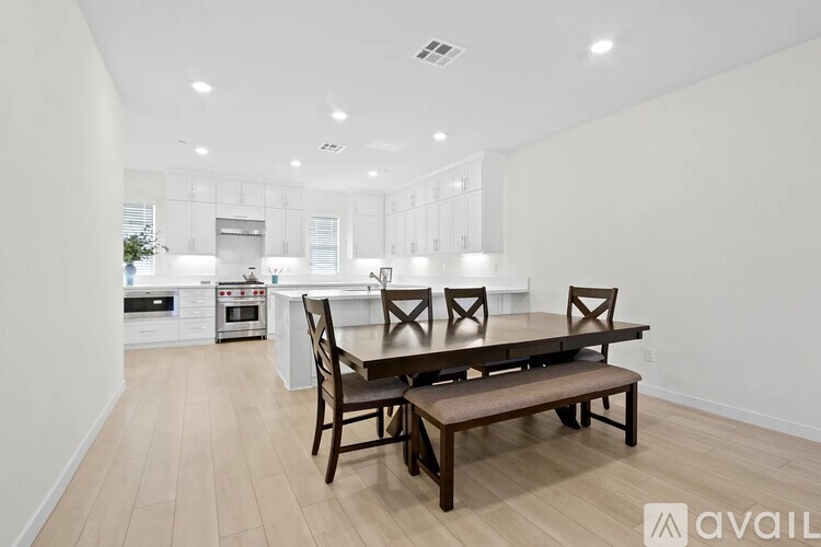A modern kitchen with a dining table and chairs.