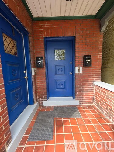 A blue door is on the left and a black mailbox is on the right.