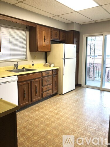 A kitchen with brown cabinets and a white refrigerator.