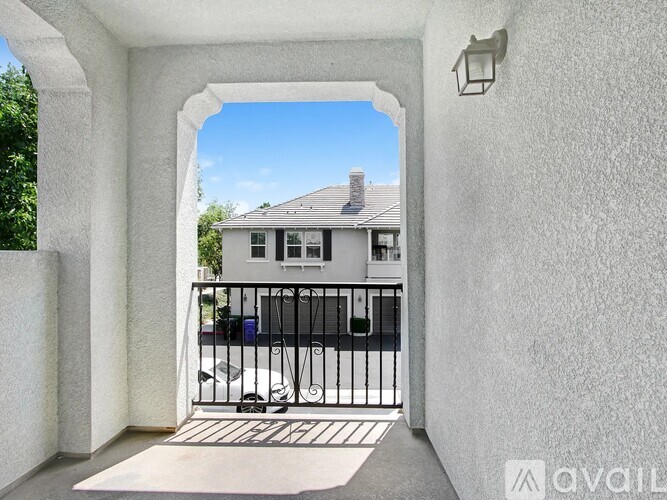 A white house is seen through an archway.