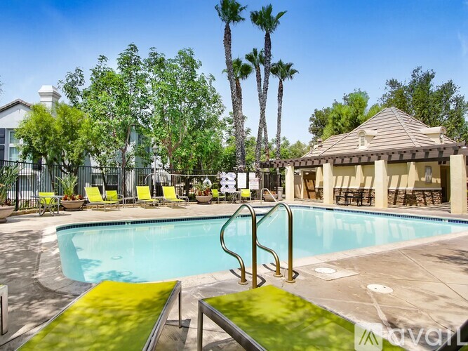 A pool surrounded by palm trees and a gazebo.