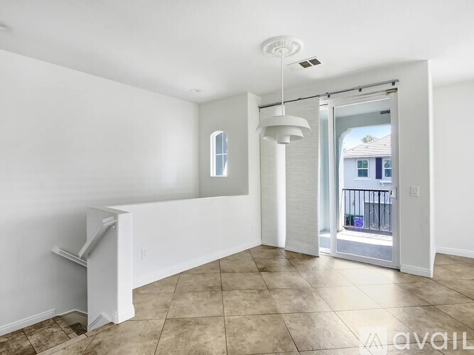 A room with a tiled floor and a sliding glass door leading to a balcony.