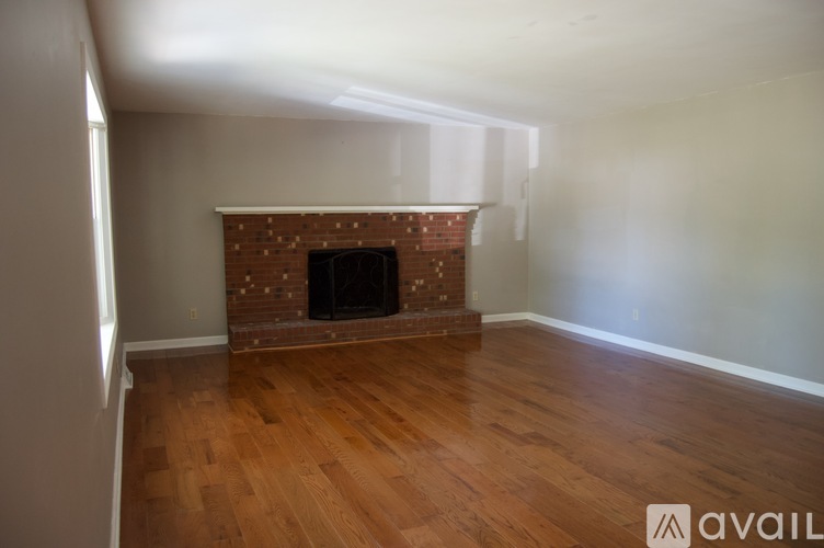 A room with a fireplace and wooden floors.