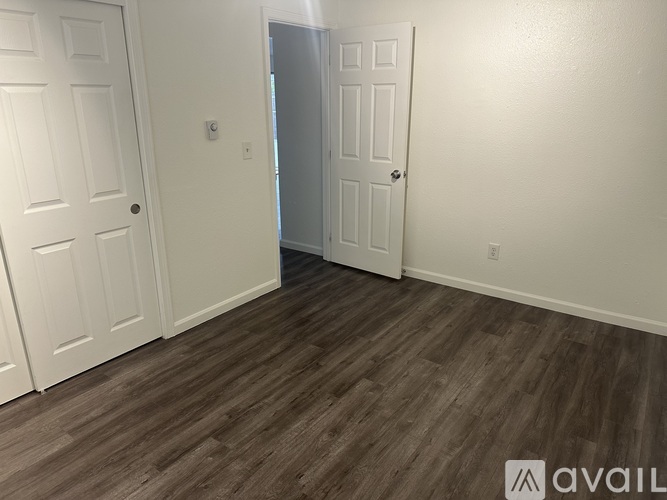 A room with white doors and a wooden floor.