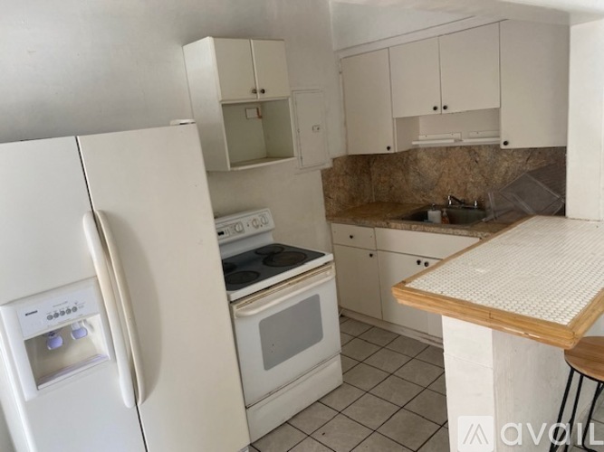 A kitchen with a white refrigerator and a white stove top oven.