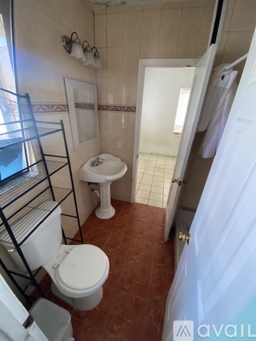 A bathroom with a toilet, sink, and a towel rack.