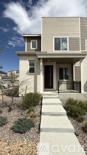 A modern house with a front yard and a stone pathway leading to the entrance.