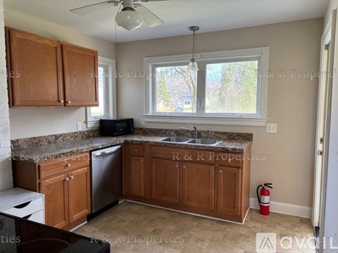 A kitchen with wooden cabinets and a black fridge.