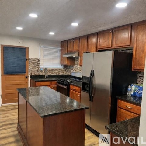 A kitchen with wooden cabinets and a granite countertop.