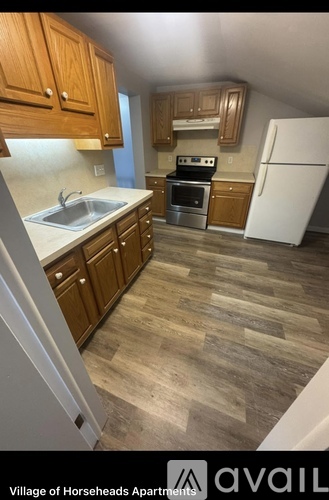 A kitchen with wooden cabinets and a white refrigerator.