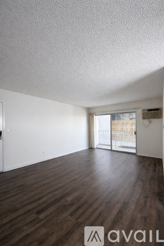 A room with wooden floors and a sliding glass door.