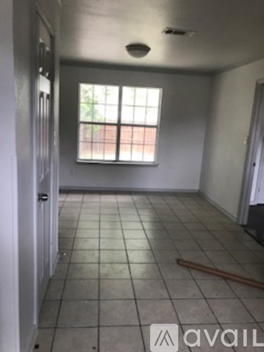 A room with a window and tiled floor.