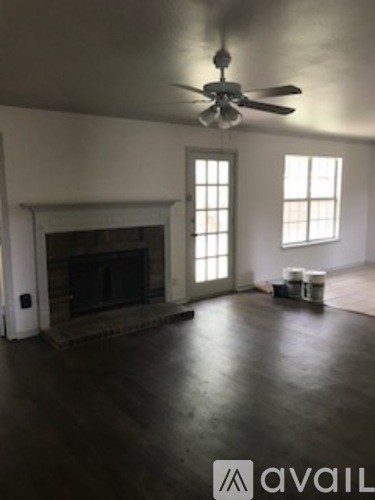 A room with a fireplace and a ceiling fan.
