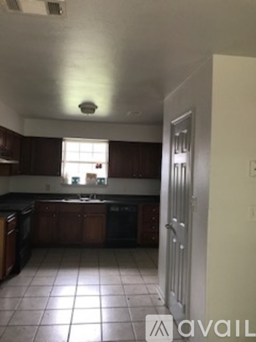 A kitchen with brown cabinets and a white door.