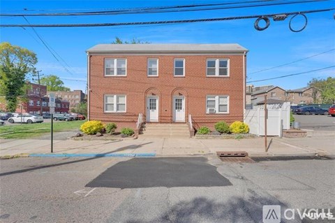 A red brick house with a white door and windows.