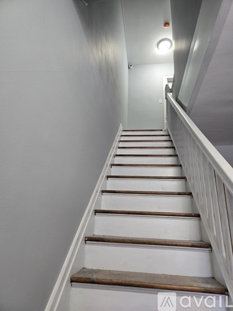 A staircase with wooden steps and white railings.